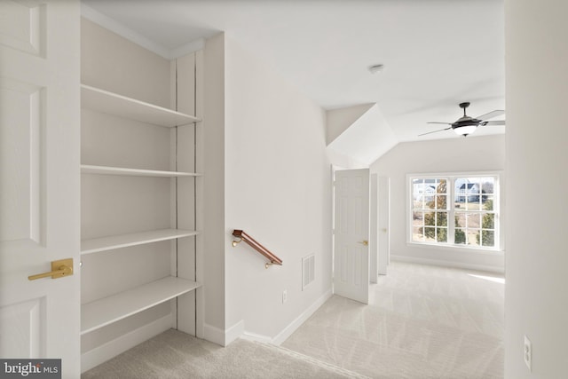 stairs with lofted ceiling, ceiling fan, and carpet