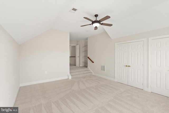 additional living space with vaulted ceiling, light colored carpet, and ceiling fan