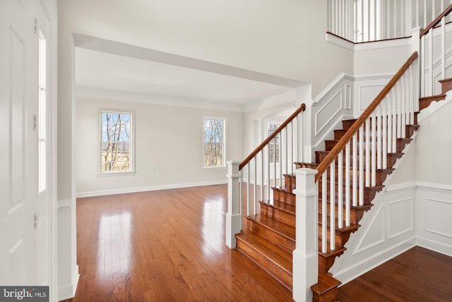 stairs featuring ornamental molding and hardwood / wood-style floors