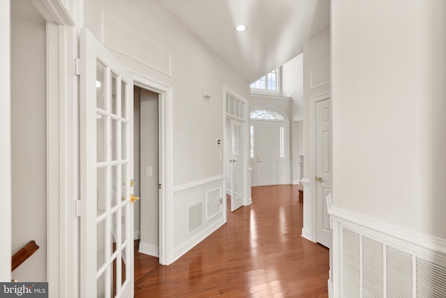 foyer entrance featuring wood-type flooring and high vaulted ceiling