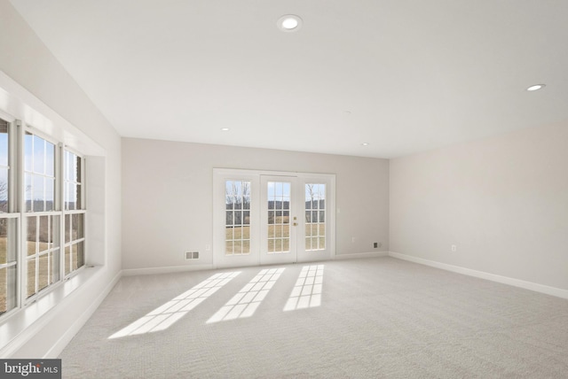 carpeted empty room featuring french doors