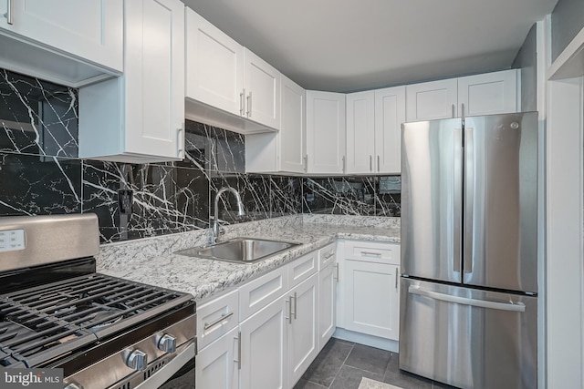 kitchen with sink, light stone countertops, tasteful backsplash, white cabinetry, and stainless steel appliances