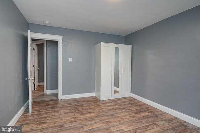 unfurnished bedroom with dark wood-type flooring