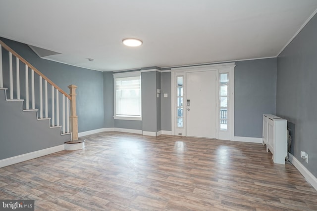 foyer entrance featuring hardwood / wood-style floors and crown molding