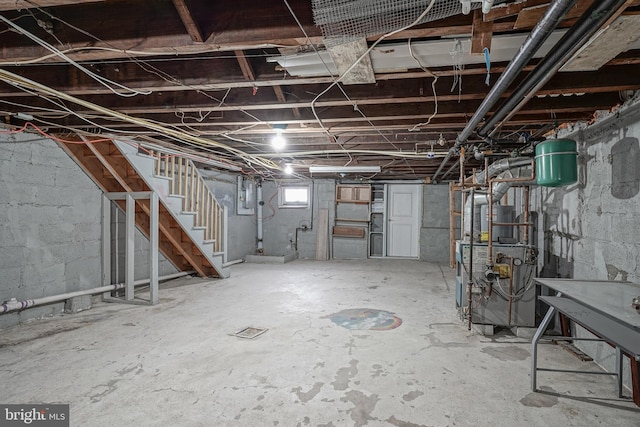 basement featuring electric panel and gas water heater