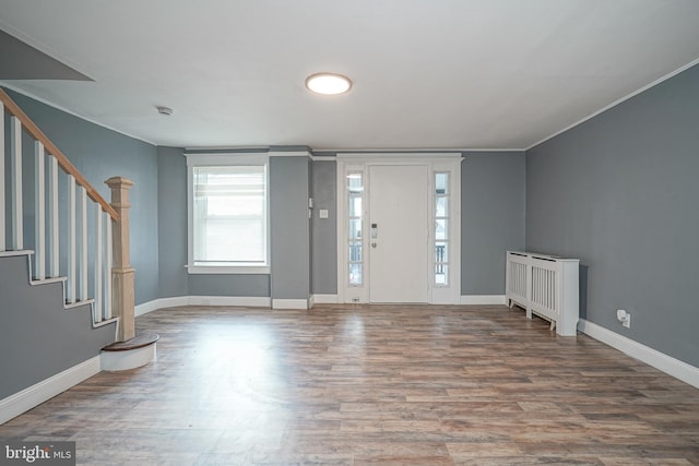 foyer featuring crown molding and wood-type flooring