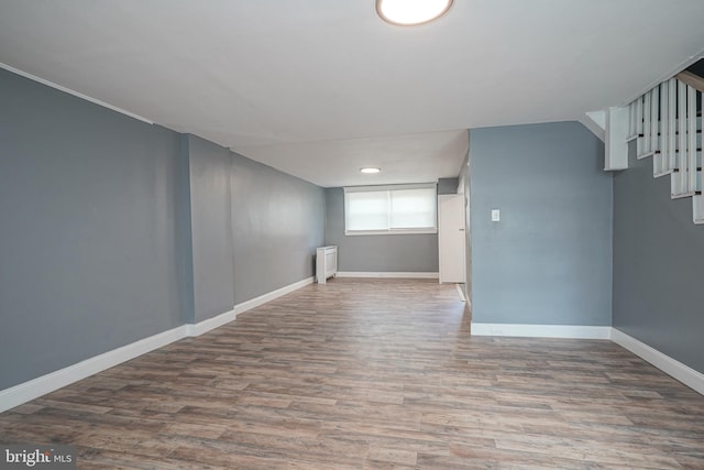 interior space with wood-type flooring and radiator heating unit