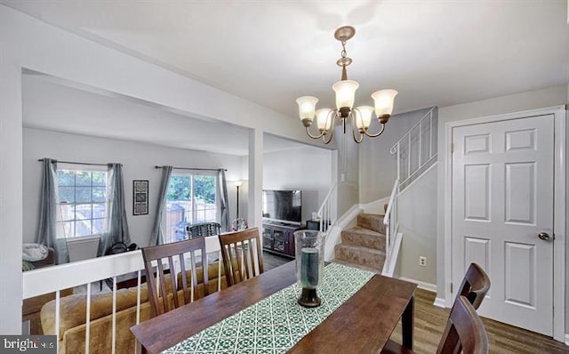 dining area with hardwood / wood-style floors and a chandelier