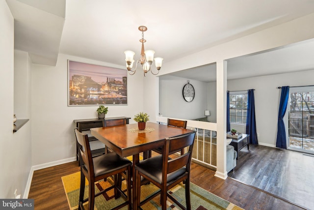 dining room with dark hardwood / wood-style flooring and a notable chandelier