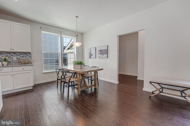 dining room with dark wood-type flooring and baseboards