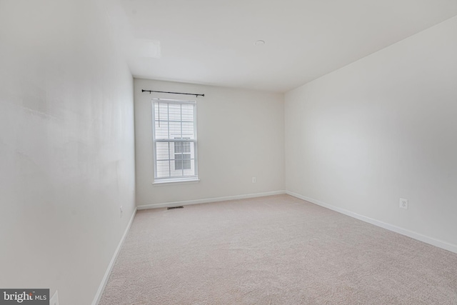 unfurnished room featuring light carpet, visible vents, and baseboards