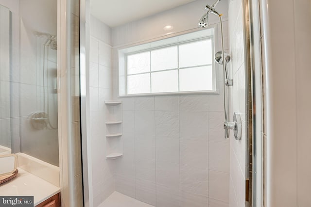 bathroom featuring vanity and a shower with door