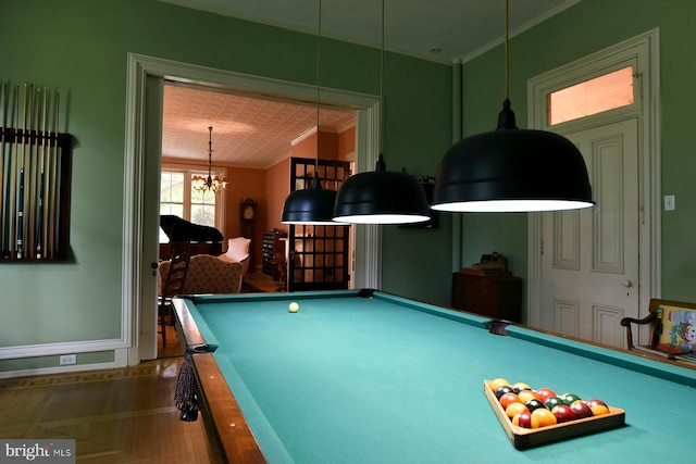 rec room featuring dark parquet floors, ornamental molding, billiards, and an inviting chandelier