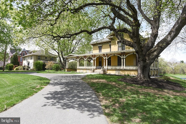 view of front of home featuring covered porch and a front lawn