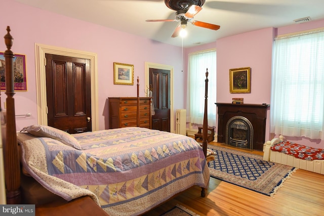 bedroom featuring radiator, ceiling fan, and wood-type flooring