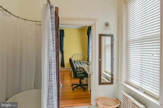 office space with radiator, a healthy amount of sunlight, and hardwood / wood-style flooring