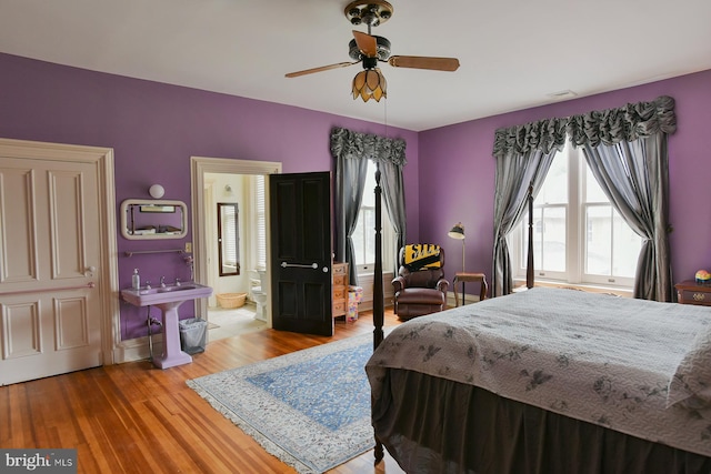 bedroom featuring hardwood / wood-style flooring, ceiling fan, and connected bathroom