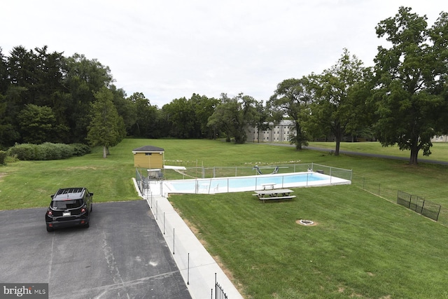 view of home's community featuring a storage unit, a yard, and a swimming pool