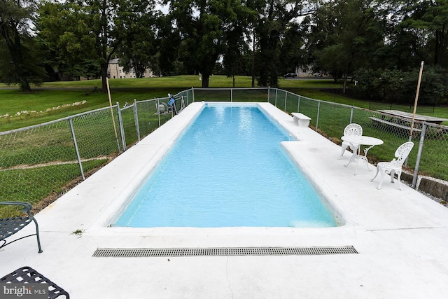 view of swimming pool featuring a yard