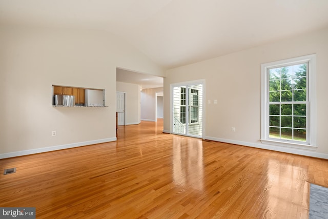 unfurnished living room featuring vaulted ceiling, baseboards, visible vents, and light wood-style floors