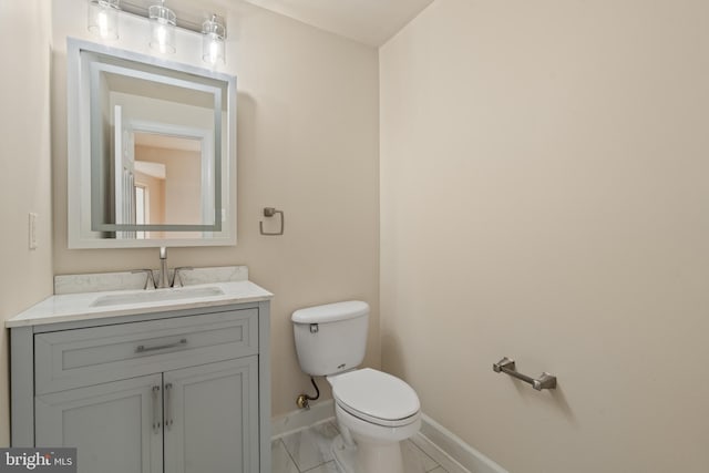 bathroom featuring marble finish floor, vanity, toilet, and baseboards