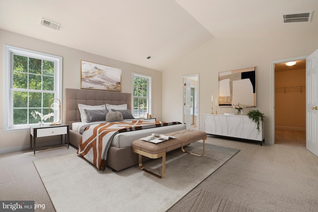 bedroom with light carpet, a spacious closet, visible vents, and vaulted ceiling