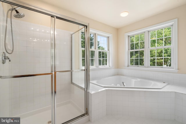 bathroom with a shower stall and a bath