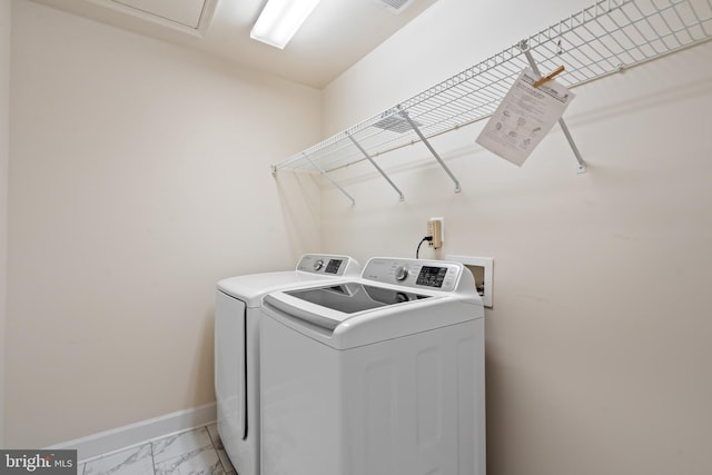 clothes washing area with marble finish floor, baseboards, laundry area, and washing machine and clothes dryer