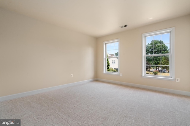 unfurnished room featuring light carpet, visible vents, and baseboards