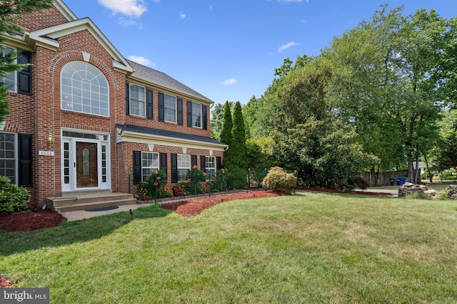 view of front of property featuring a front yard and brick siding