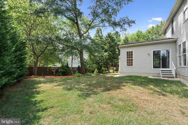 view of yard featuring entry steps and fence