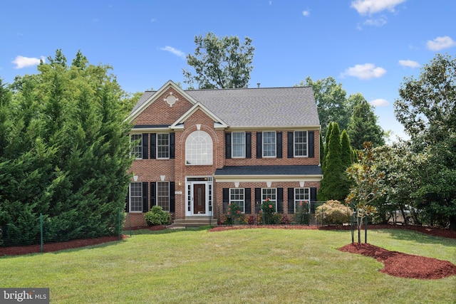 colonial-style house with a front yard and brick siding