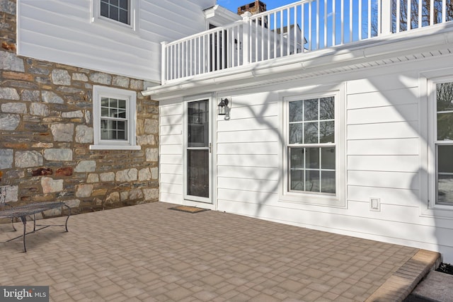 entrance to property featuring a balcony and a patio area