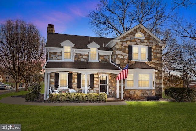 front facade with a porch and a lawn