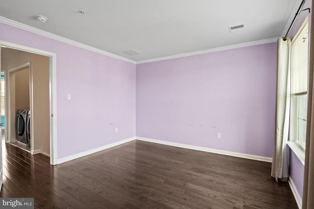 spare room with washing machine and dryer, baseboards, dark wood finished floors, and crown molding