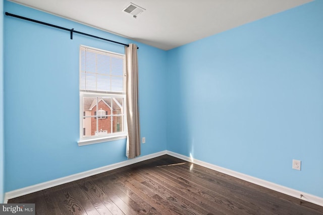 spare room with visible vents, baseboards, and wood finished floors