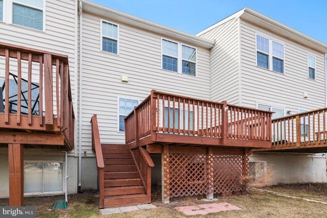 back of property featuring stairway and a deck