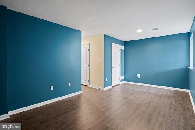 unfurnished bedroom with visible vents, baseboards, and wood finished floors