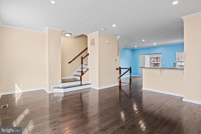 unfurnished living room featuring ornamental molding, recessed lighting, dark wood finished floors, and baseboards