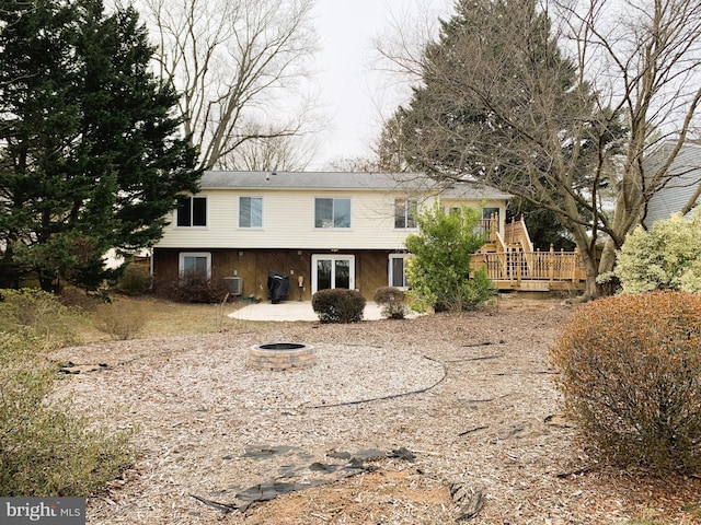 back of house featuring central AC unit, an outdoor fire pit, and a deck