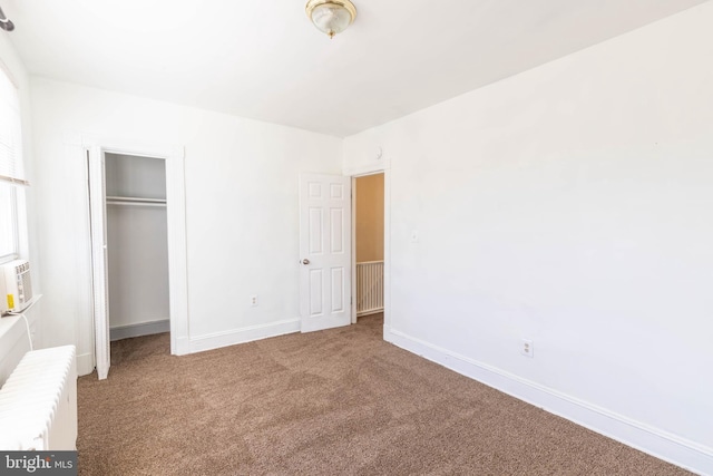 unfurnished bedroom featuring carpet flooring, a closet, and radiator heating unit