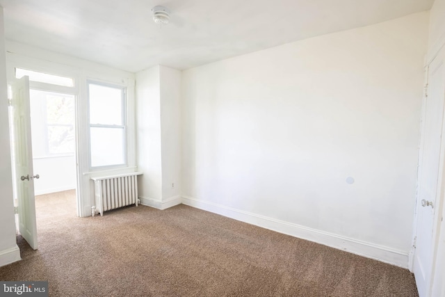 carpeted empty room with radiator heating unit