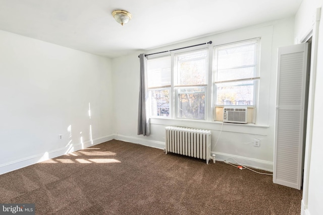 carpeted spare room with cooling unit and radiator heating unit