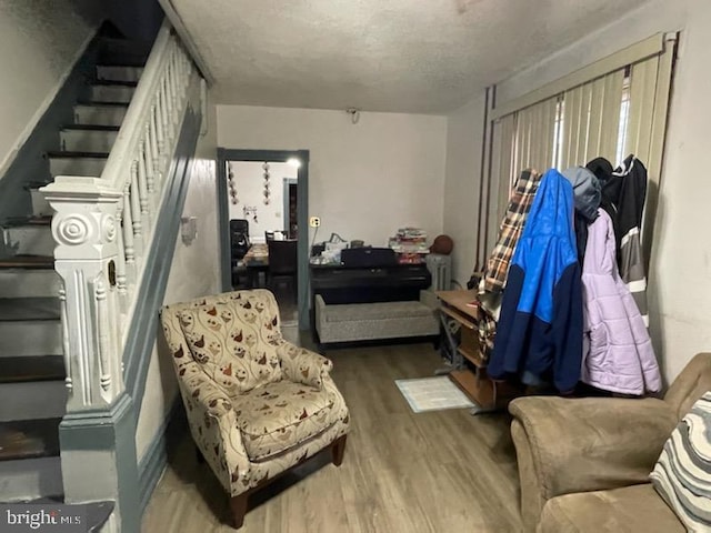 living area with a textured ceiling and hardwood / wood-style flooring