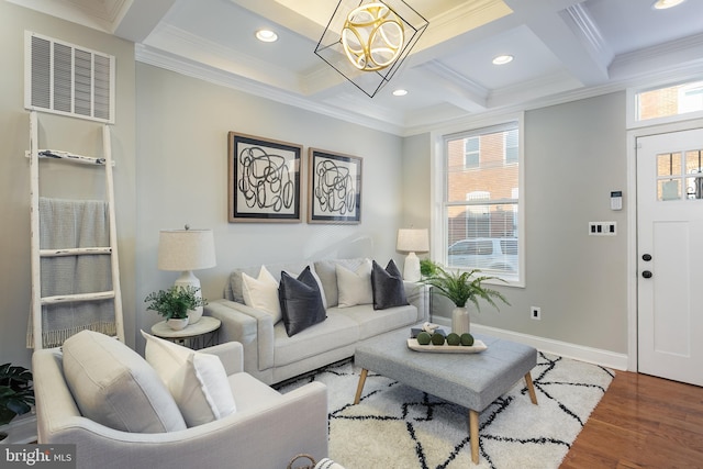 living room with beam ceiling, dark wood-type flooring, coffered ceiling, a notable chandelier, and crown molding