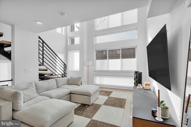 living room featuring wood-type flooring and a towering ceiling