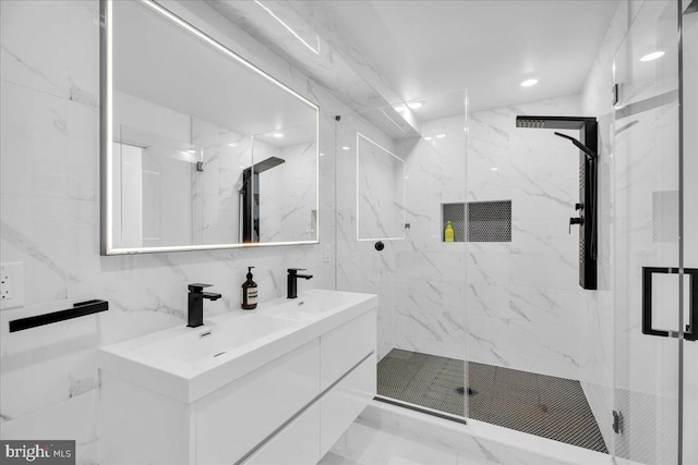 bathroom featuring vanity, a shower with shower door, and tile walls