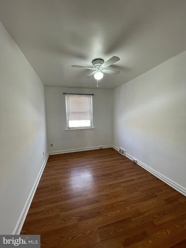 empty room featuring ceiling fan and dark wood-type flooring