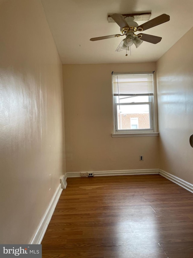 empty room with ceiling fan and dark hardwood / wood-style floors