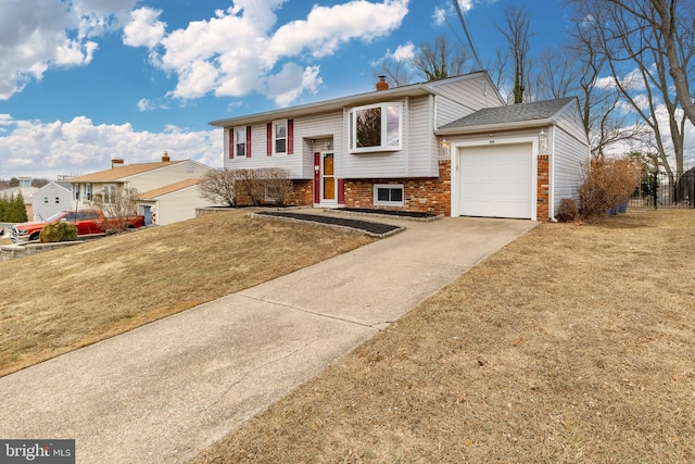 raised ranch featuring a garage and a front yard